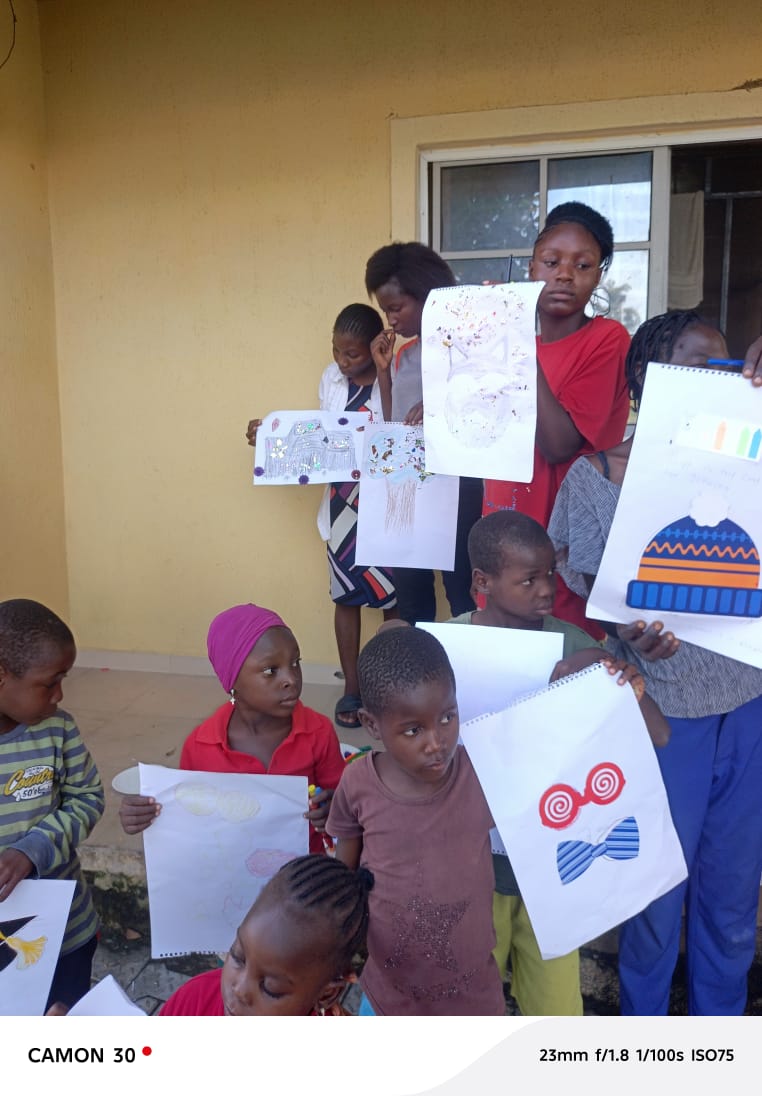 Children proudly displaying their artwork at a VIN-JPIC creativity and empowerment workshop