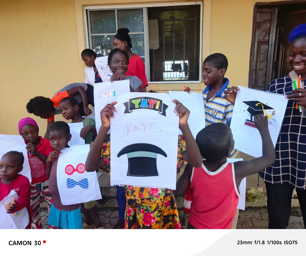 Children holding up creative artwork at a workshop